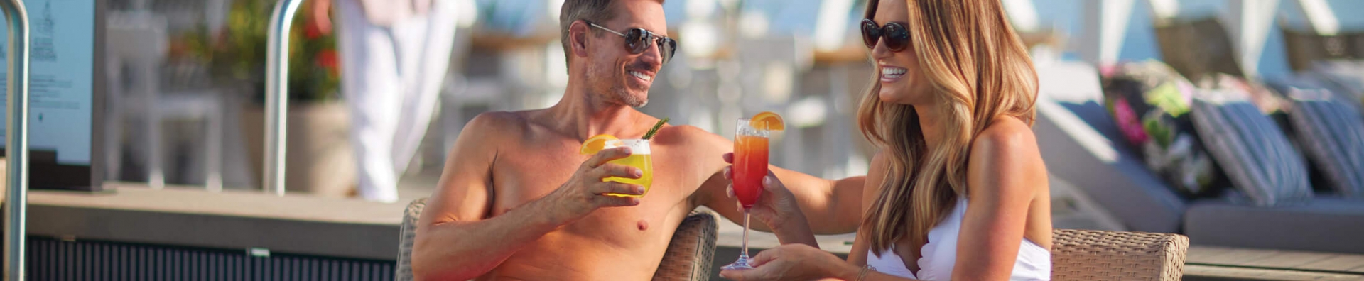 A couple lounging in a pool with tropical drinks