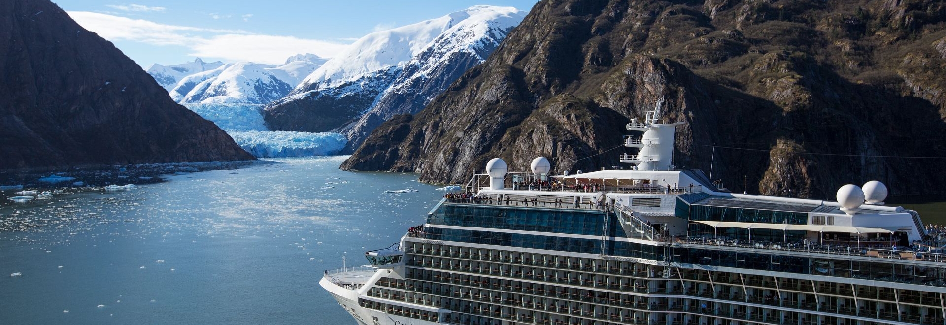 An aerial of the Celebrity Solstice sailing through a fjord
