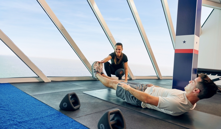 A fitness trainer coaching a young man in a weight room